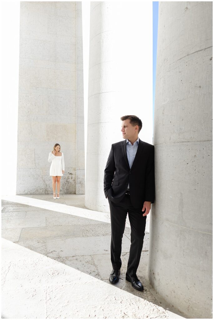 Engagement photo highlighting couple’s elegant outfits with Ohio Statehouse columns behind them